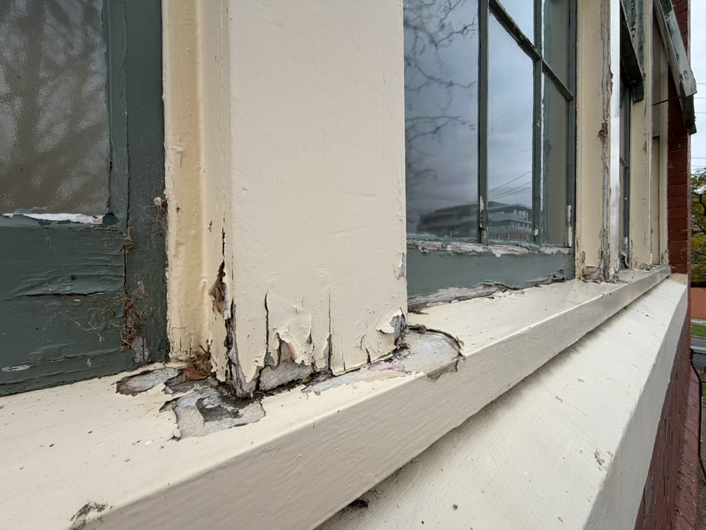 Severely rotted window sill and mullion on the heritage building